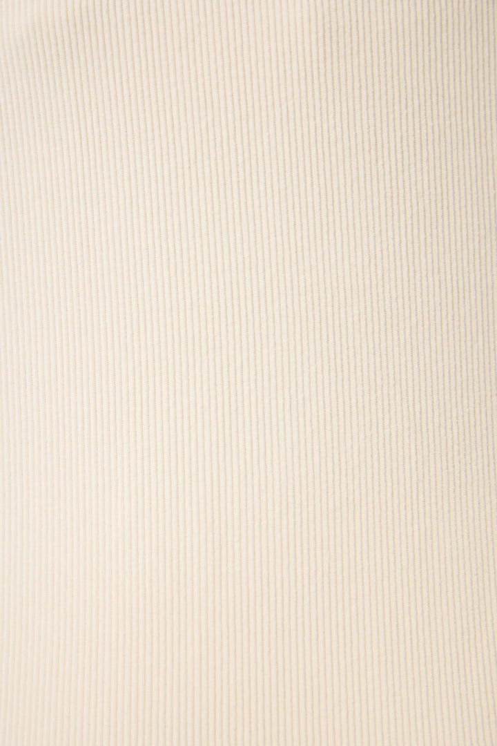 Close-up of SOLID PJ SET CRAVING CORDUROY by P.J. Salvage, featuring beige ribbed fabric with vertical textured lines. Even lighting enhances the detailed texture and softness of the material.
