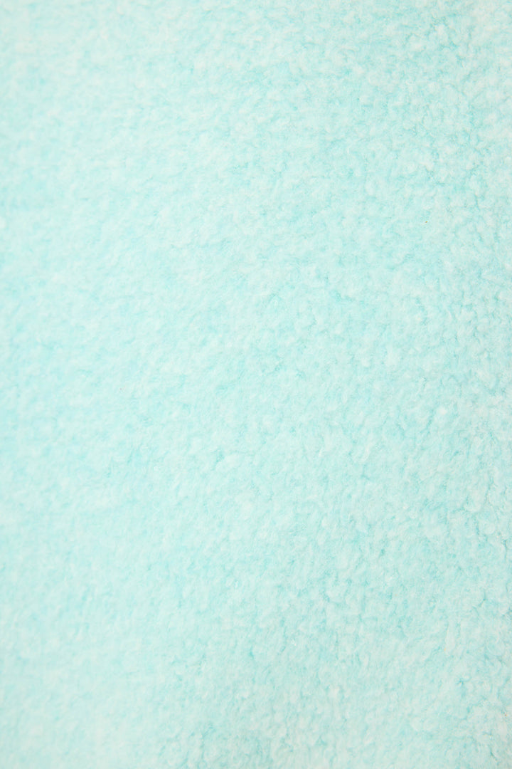 Close-up of the Secret Garden Weekend Graphic Sweatshirt by P.J. Salvage, featuring a textured light blue fabric with a soft, fluffy feel and slightly uneven, fleece-like surface.