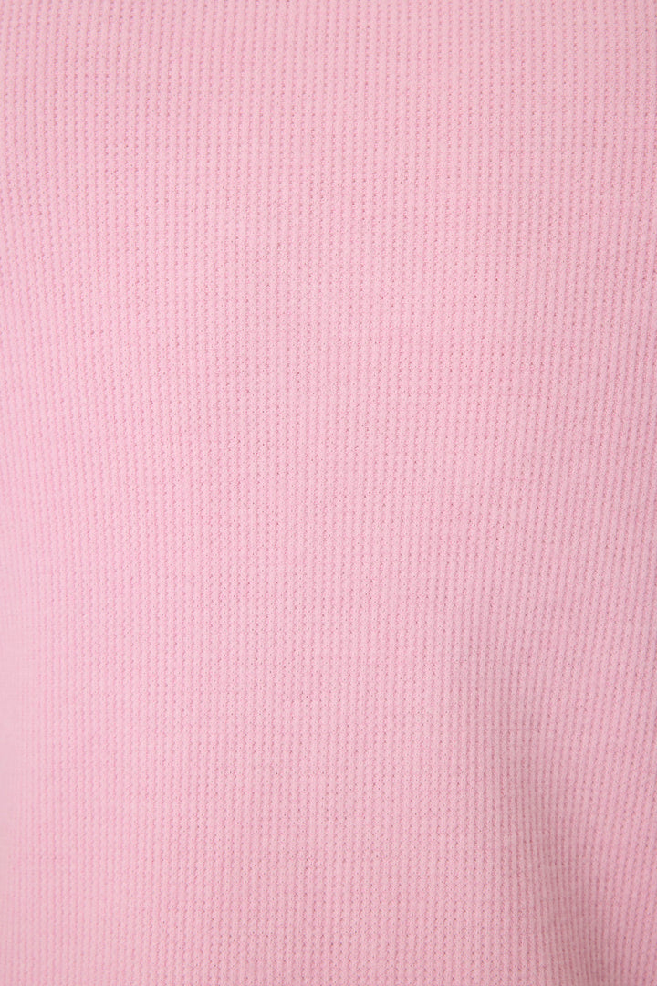 Close-up of the Wish You Were Here Peachy Short Sleeve Top by P.J. Salvage, featuring soft, smooth pink ribbed fabric with evenly spaced vertical textured lines.