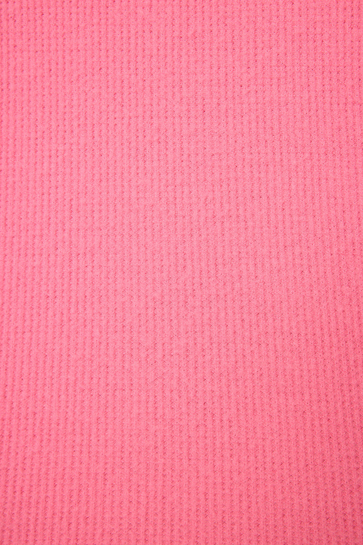 Close-up of the P.J. Salvage Boyfriend Boxer Solid Pink Short Set shows its pink ribbed fabric with vertical lines and a soft, slightly fuzzy texture.