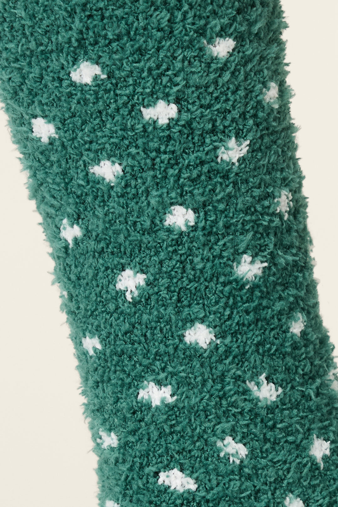 A close-up of the Let's Get Toasty Dot Print Crew Socks with Grippers by P.J. Salvage, featuring fuzzy green fabric with small white polka dots.