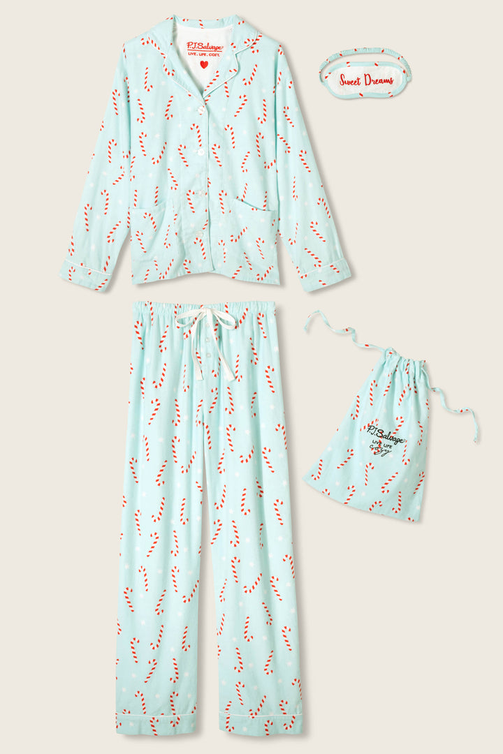 The P.J. Salvage 4-Piece Candy Cane Print Flannel PJ Set features light blue pajamas with a red and white candy cane pattern, a long-sleeved top, pants, matching drawstring bag, and a “Sweet Dreams” eye mask.