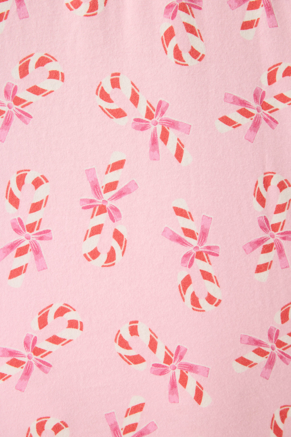The P.J. Salvage 3-Piece Candy Cane Print Plus Size Flannel PJ Set features a pink background with a red and white candy cane pattern, some with pink bows, evenly spaced across the entire fabric.