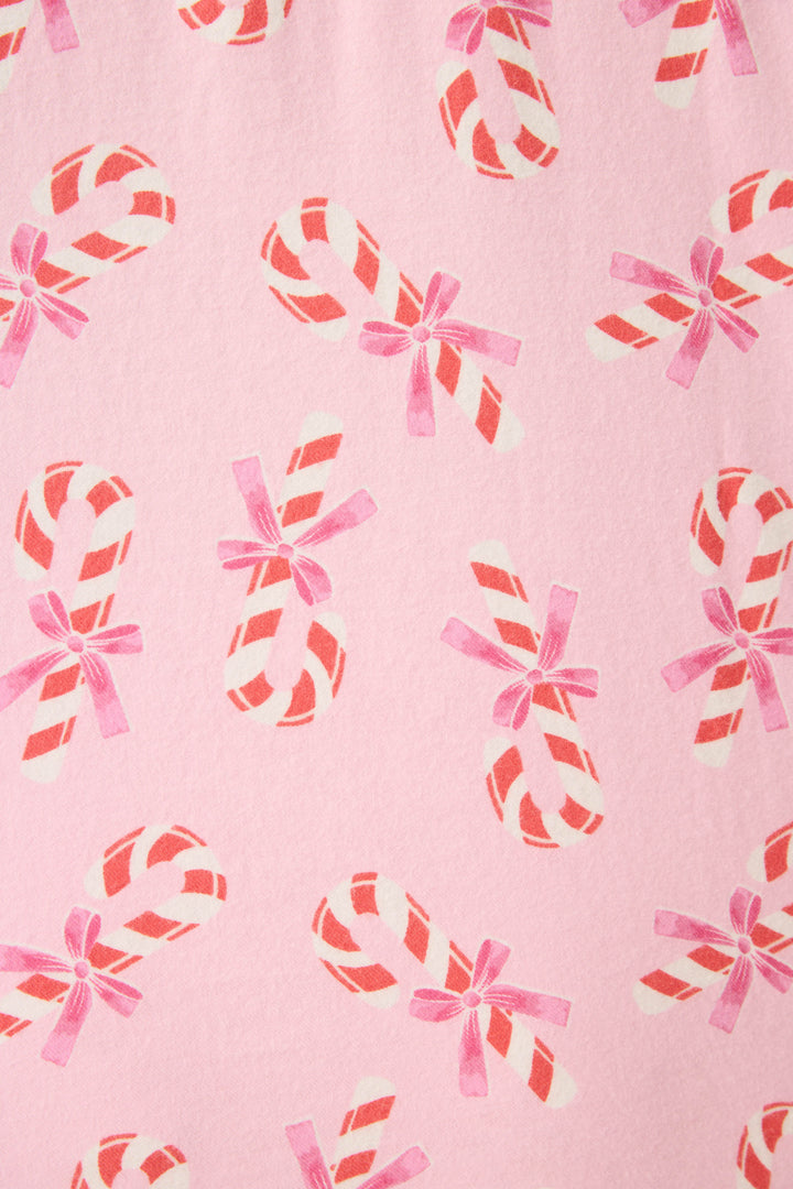 The P.J. Salvage 3-Piece Candy Cane Print Plus Size Flannel PJ Set features a pink background with a red and white candy cane pattern, some with pink bows, evenly spaced across the entire fabric.