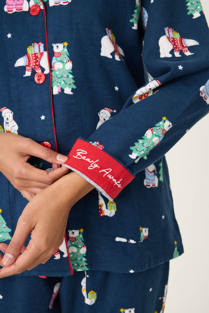 Someone wears the P.J. Salvage 3-Piece Bear Print Flannel PJ Set, featuring navy blue fabric with polar bear and Christmas tree prints, plus red-trimmed sleeves embroidered with "Beeity Aunt" in white script.