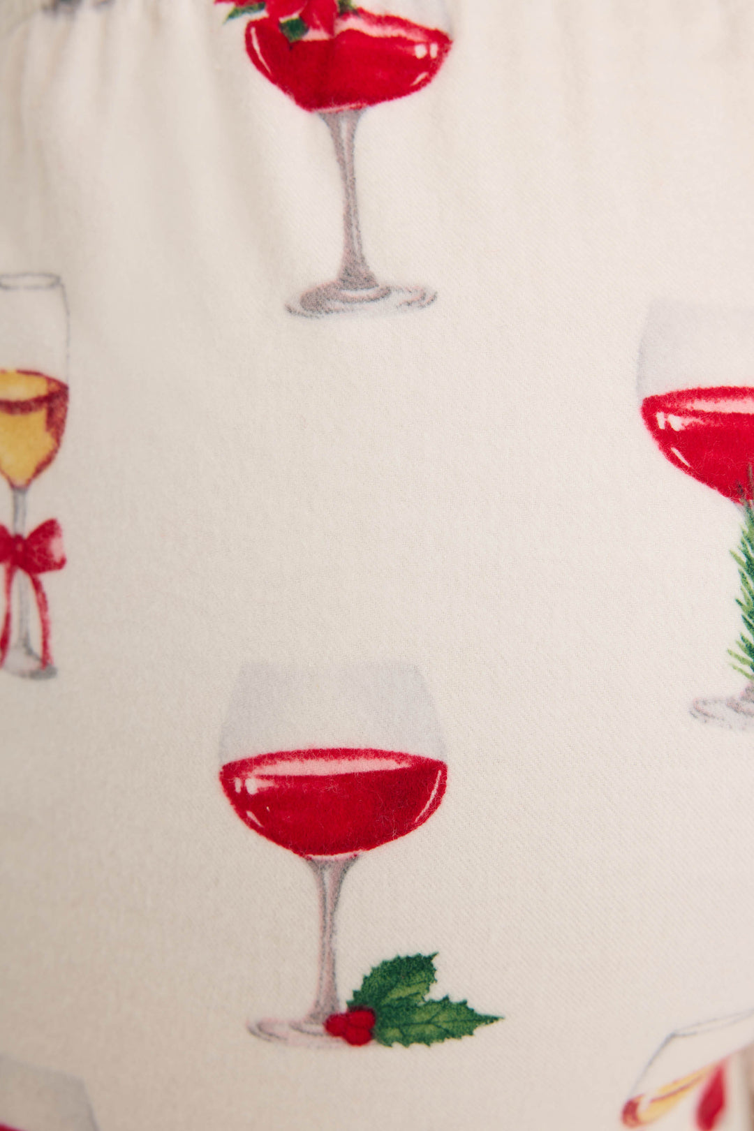 Close-up of the P.J. Salvage Let's Get Toasty Flannel Shorts, featuring festive wine glasses, holly, bows, and pine—perfect for holiday lounging in cozy cotton flannel.