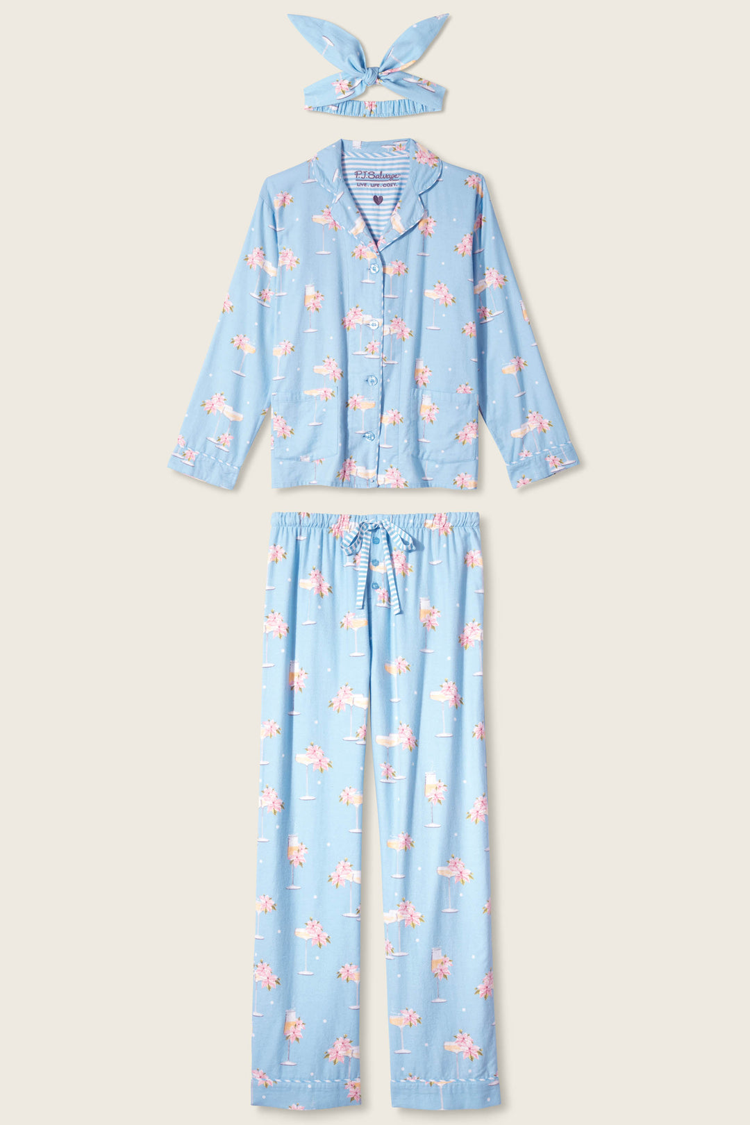 The P.J. Salvage Fizz The Season 3-Piece Flannel PJ Set is light blue with long sleeves and pants, featuring a pink floral pattern. Includes a matching sleep mask displayed above the top against a plain light background.