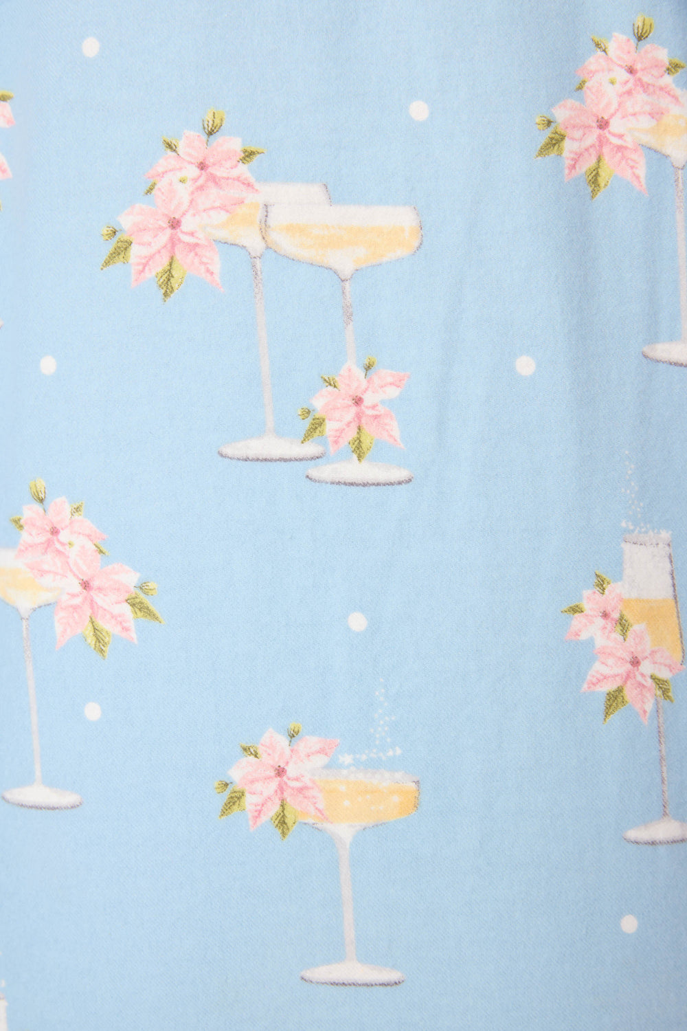 The Fizz The Season 3-Piece Flannel PJ Set by P.J. Salvage features light blue fabric with white polka dots and prints of champagne coupe and flute glasses adorned with pink poinsettias and green leaves.