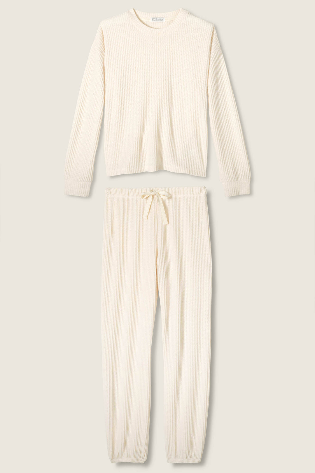 The SOLID PJ SET FIRESIDE SPARKLE SET by P.J. Salvage features a cream-colored, ribbed knit loungewear set with a long-sleeved top and drawstring pants with elastic cuffs, displayed flat on a neutral background.