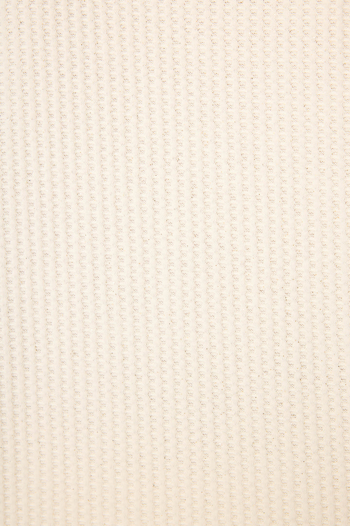 Close-up of the SOLID PJ SET FIRESIDE SPARKLE SETS by P.J. Salvage, featuring a soft beige fabric with a woven look and a regular, raised grid pattern running vertically and horizontally across the surface.