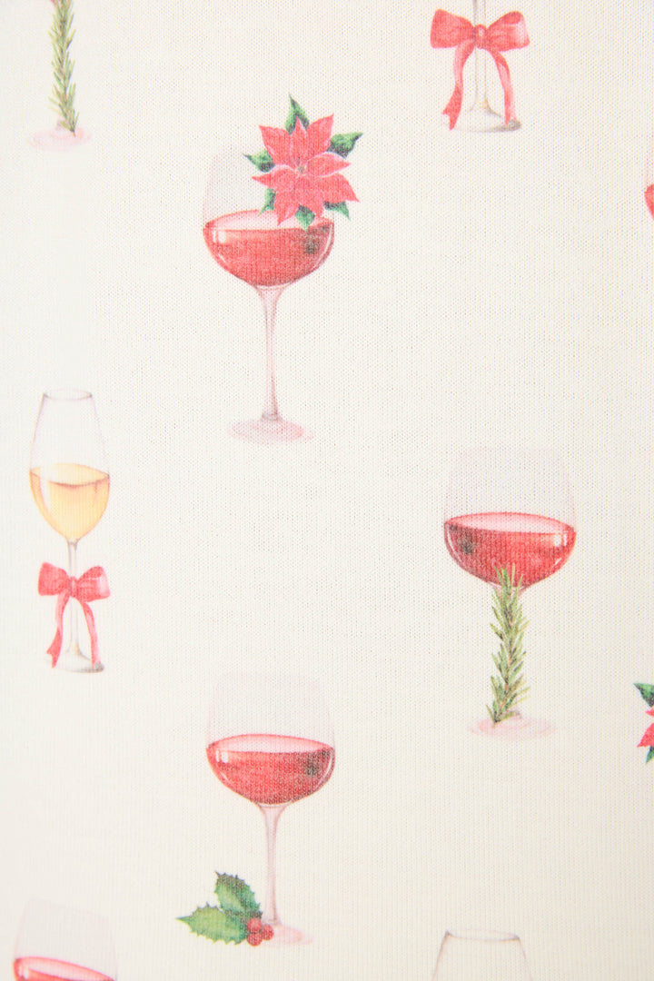 The Let's Get Toasty Holiday Wine Print Pants Set by P.J. Salvage features a festive cream backdrop with wine glasses filled with white or red wine, each accented by holly, bows, poinsettias, or rosemary.