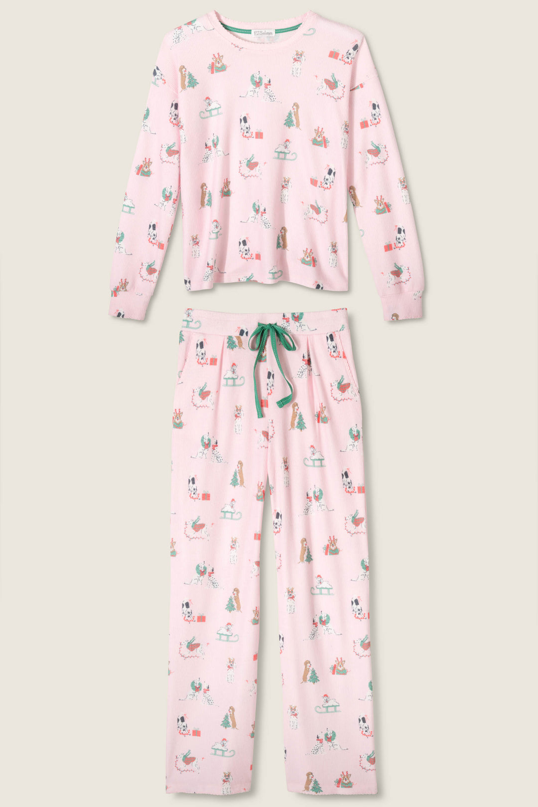 The Peace & Pawlidays Dog Print Pants Set by P.J. Salvage is a pink pajama set with a long-sleeve top and pants, both featuring colorful dog, bone, and tennis ball prints, plus a green drawstring waist.