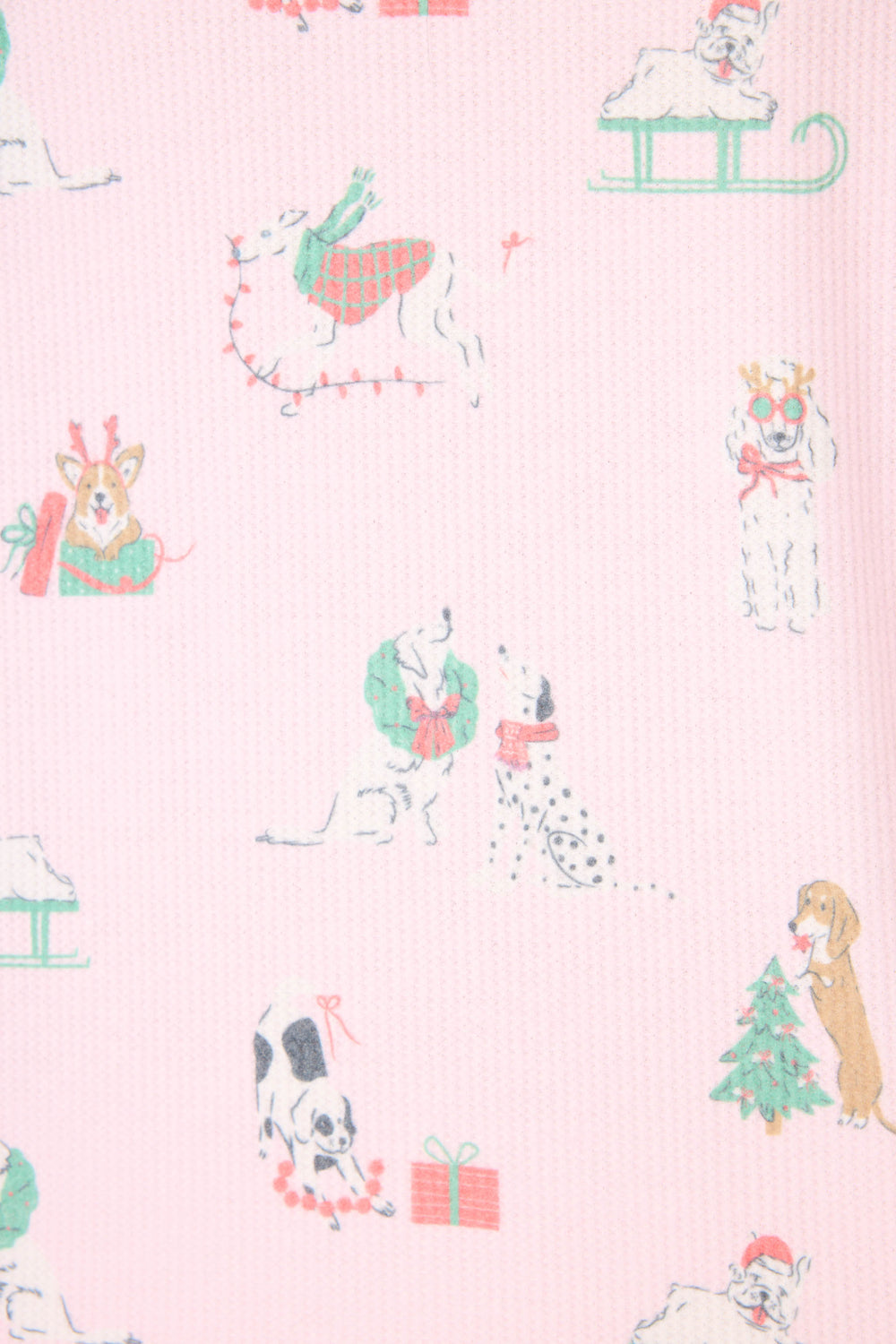 The P.J. Salvage Peace & Pawlidays Dog Print Pants Set features pink fabric decorated with festive dog illustrations, including pups in scarves, with wreaths, sledding, playing with lights, and a Christmas tree with a present.