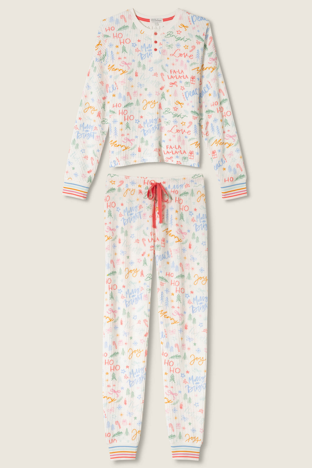 The P.J. Salvage Ski Jammie Holiday Print PJ Set features a white button-up long-sleeve top and drawstring pants adorned with colorful holiday text and doodles, plus striped cuffs on both the sleeves and pant legs.