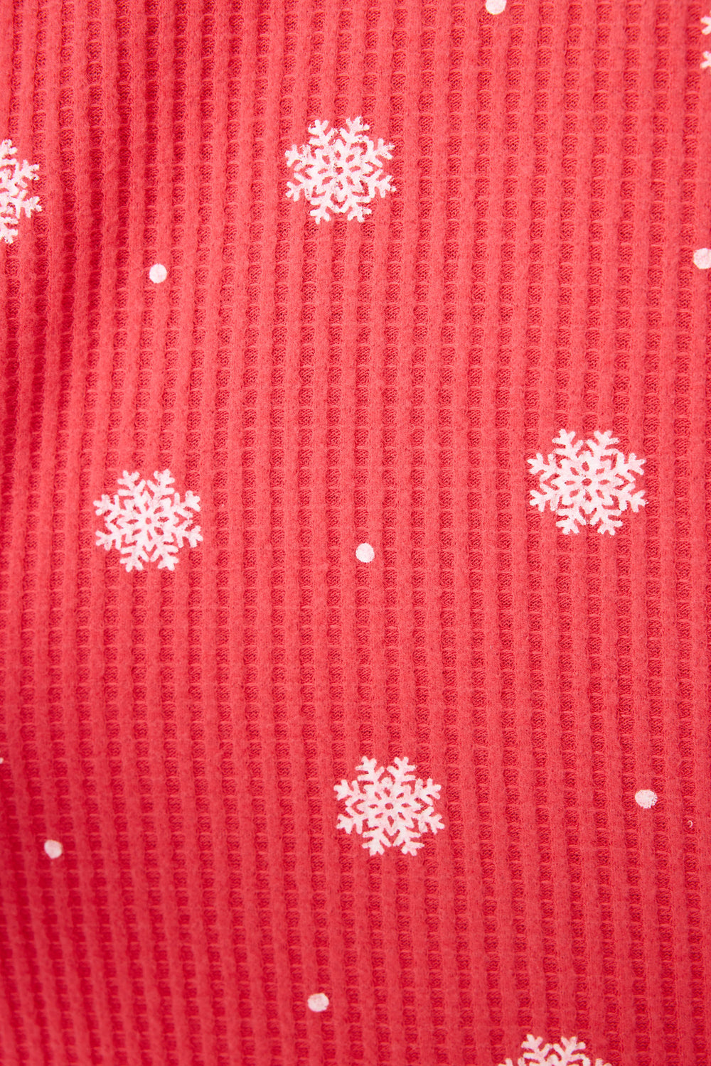 The Ski Jammie Snowflake Print PJ Set by P.J. Salvage features red fabric with a textured, waffle-like pattern and an allover print of evenly spaced white snowflakes and small white dots.