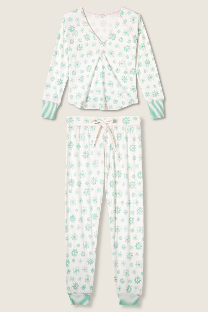 The Snowflake Wishes Pointelle Pants Set by P.J. Salvage features a two-piece brushed pointelle pajama set with a long-sleeve top and drawstring pants in a light green floral print and striped cuffs at the wrists and ankles.