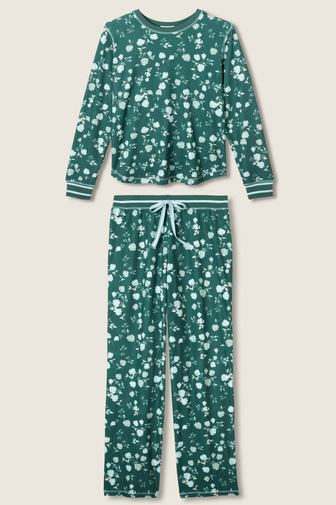 The FLORAL PJ SET WINTER LAND by P.J. Salvage is a two-piece dark green pajama set with a long-sleeve top and matching pants, featuring a white floral pattern and light blue striped accents on the cuffs, waistband, and drawstring.