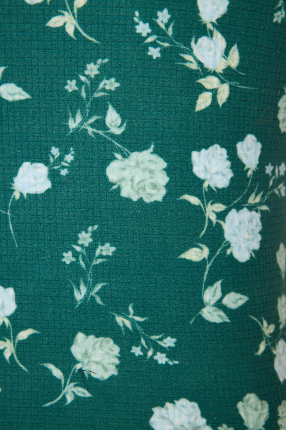 Close-up of the FLORAL RACERBACK TANK WINTER LAND by P.J. Salvage, featuring green textured fabric with a white and light yellow floral rose pattern scattered throughout.
