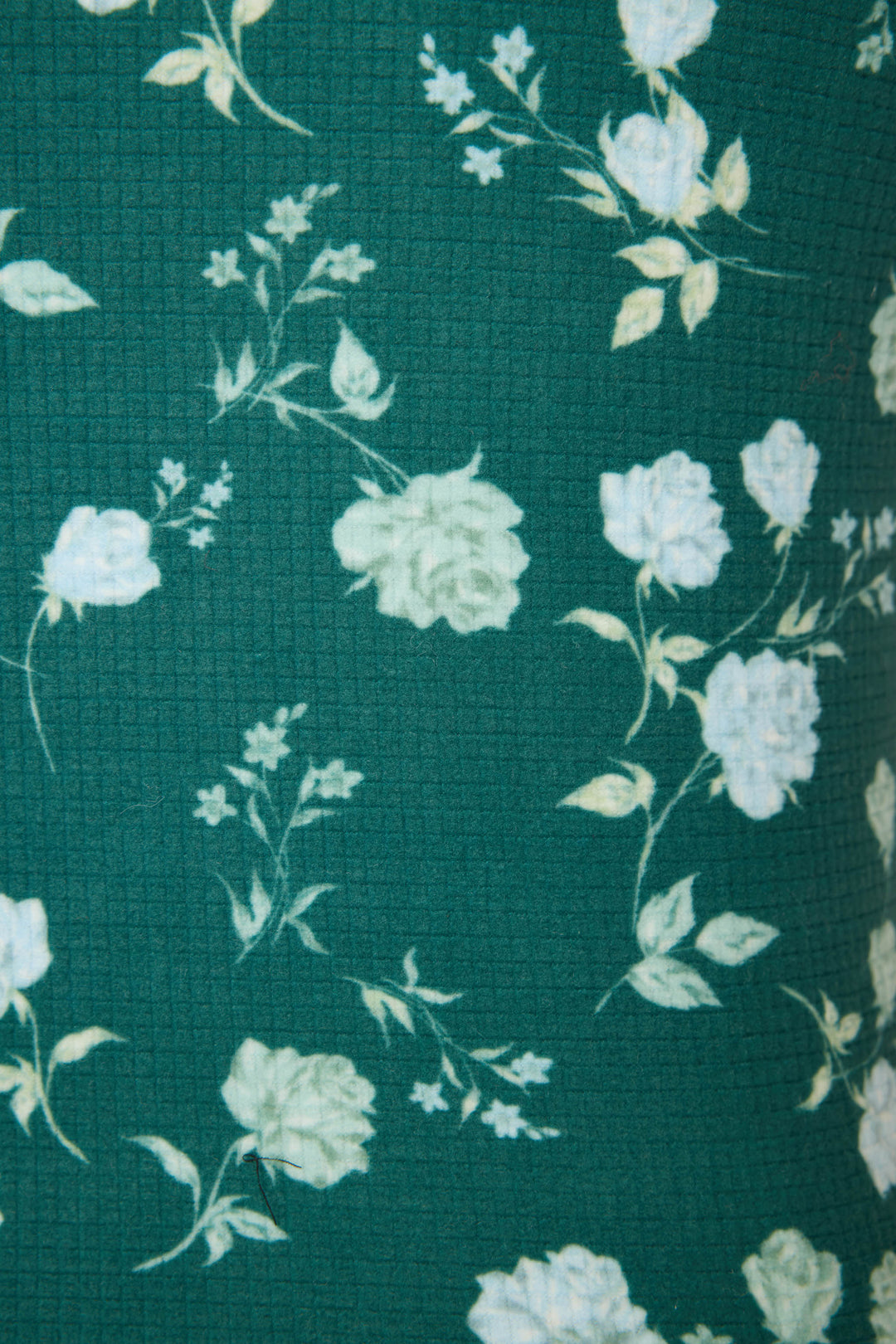 Close-up of the FLORAL RACERBACK TANK WINTER LAND by P.J. Salvage, featuring green textured fabric with a white and light yellow floral rose pattern scattered throughout.