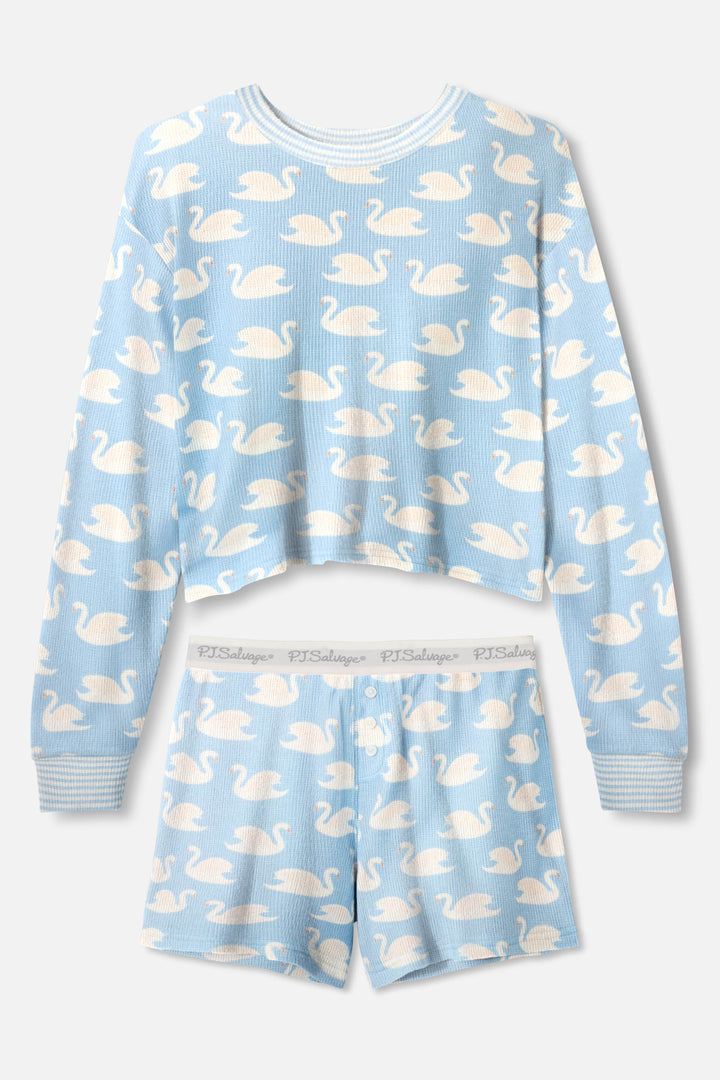 The P.J. Salvage Boyfriend Boxer Swans-A-Swimming PJ Short Set includes a light blue long-sleeve top and shorts with a white swan print, cozy ribbed waffle fabric, and a logo-patterned waistband for playful sleepwear style.