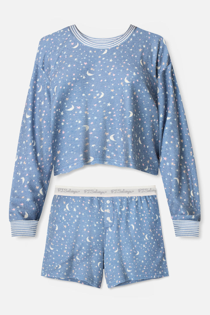 The Boyfriend Boxer Moon & Stars PJ Short Set by P.J. Salvage features a blue celestial design with white moons and stars, a long-sleeve top and shorts with ribbed cuffs, plus a white elastic waistband reading PJ Salvage.
