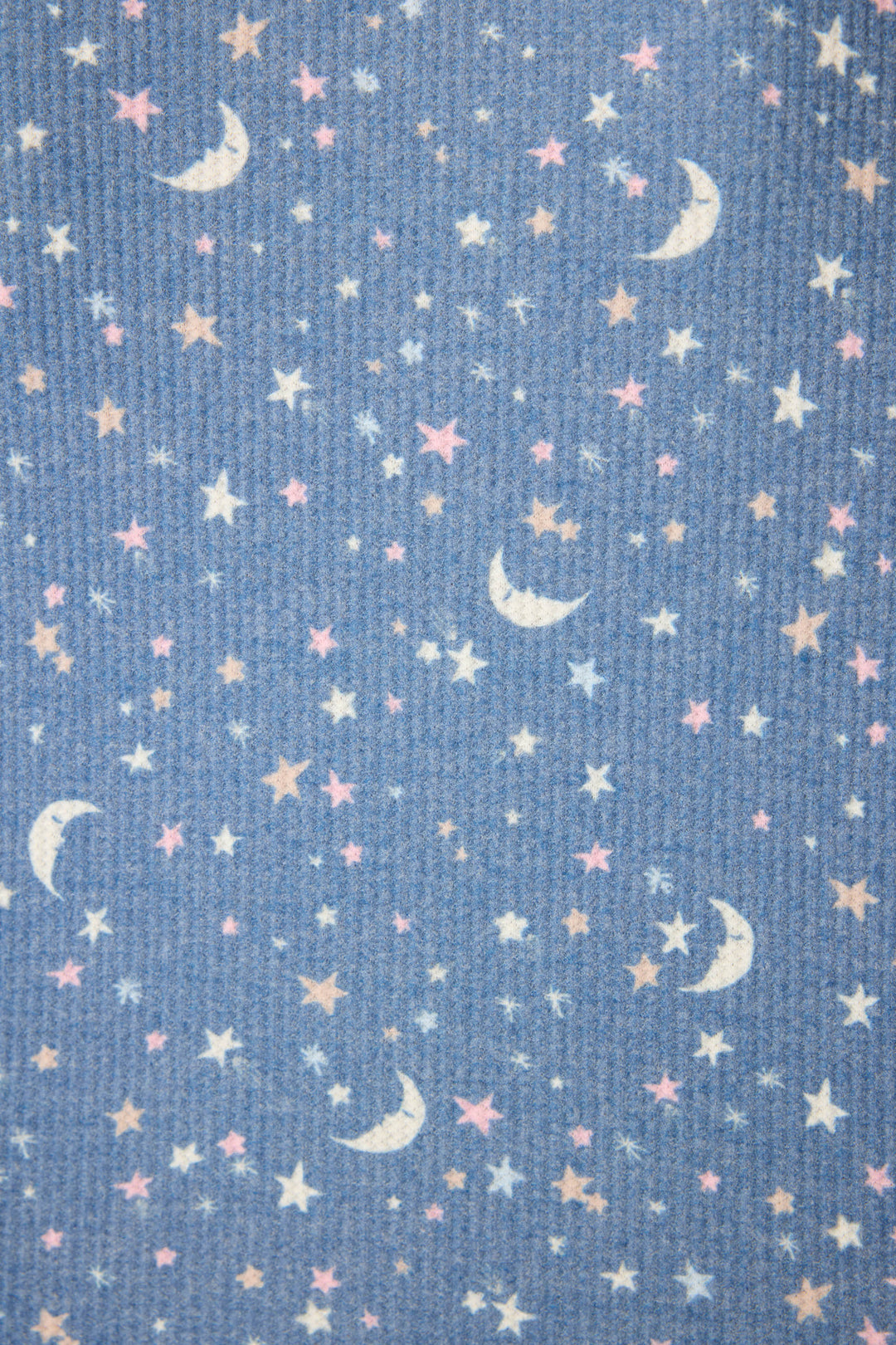 The P.J. Salvage Boyfriend Boxer Moon & Stars PJ Short Set features textured blue waffle fabric with a celestial print of white crescent moons and scattered stars in white, yellow, and pink—perfect for cozy nights.