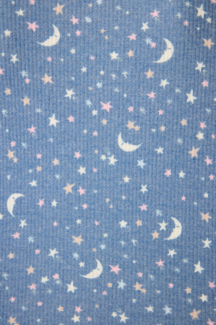 The P.J. Salvage Boyfriend Boxer Moon & Stars PJ Short Set features textured blue waffle fabric with a celestial print of white crescent moons and scattered stars in white, yellow, and pink—perfect for cozy nights.