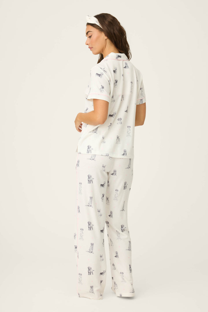 A woman faces away, wearing the P.J. Salvage "My Dog Is My Valentine" 3-piece PJ set—white with a dog print and matching headband—against a plain, light background.
