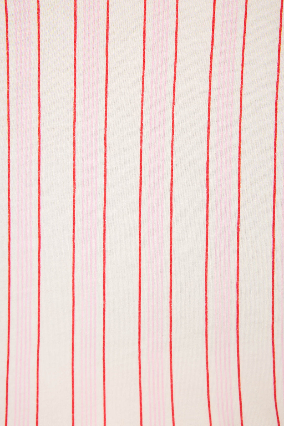 The Feeling Loved Striped PJ Set by P.J. Salvage features white fabric with alternating red and light pink vertical stripes in varying thicknesses for a simple, repetitive look.