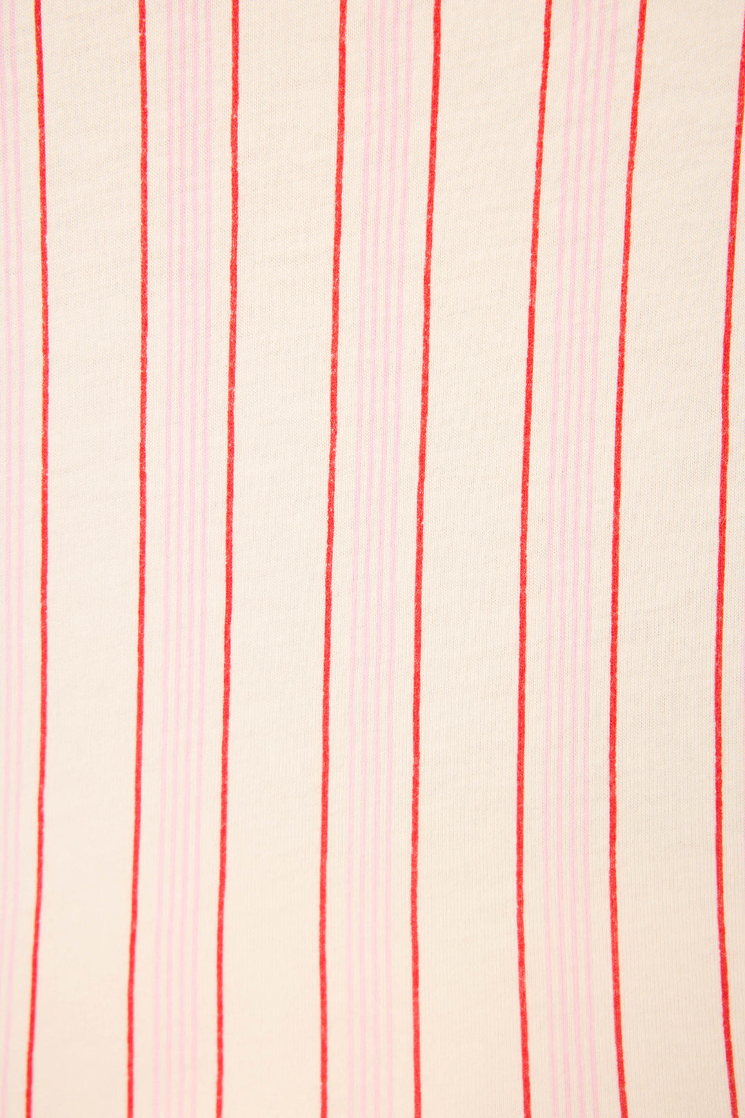 The Feeling Loved Striped Open Leg Pants by P.J. Salvage feature a beige surface with evenly spaced vertical red and pink stripes, reminiscent of cozy pajama pants. The stripes vary in thickness and spacing, running vertically throughout.