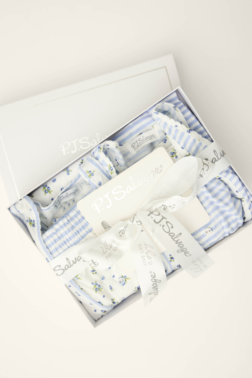 The Mix and Match Blueberry Dreams Sleep Set by P.J. Salvage features blue and white floral and striped sleepwear, elegantly boxed with branded ribbon and packaging, shown from above on a light background.