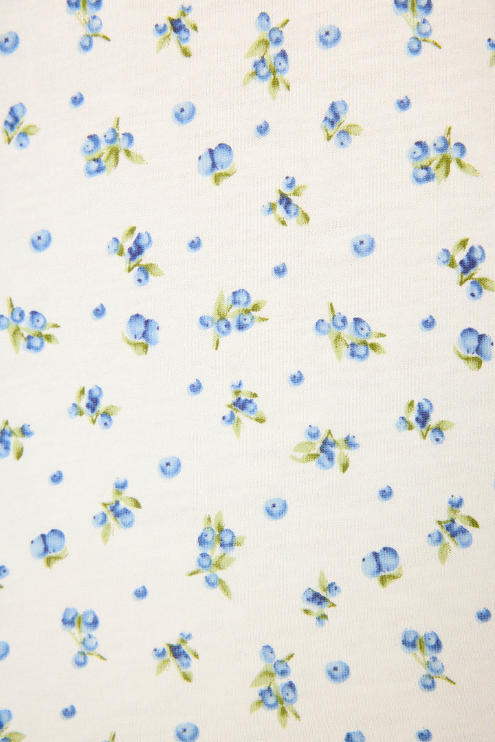 The Mix and Match Blueberry Dreams Sleep Set by P.J. Salvage features a white fabric with evenly spaced clusters of blue and light purple blueberries and green leaves for a fresh, playful look.
