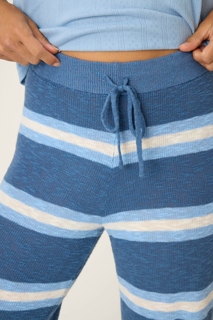 A person wears the P.J. Salvage More Amour Striped Open Leg Pants with a light blue knit top; only the torso and upper legs are visible.