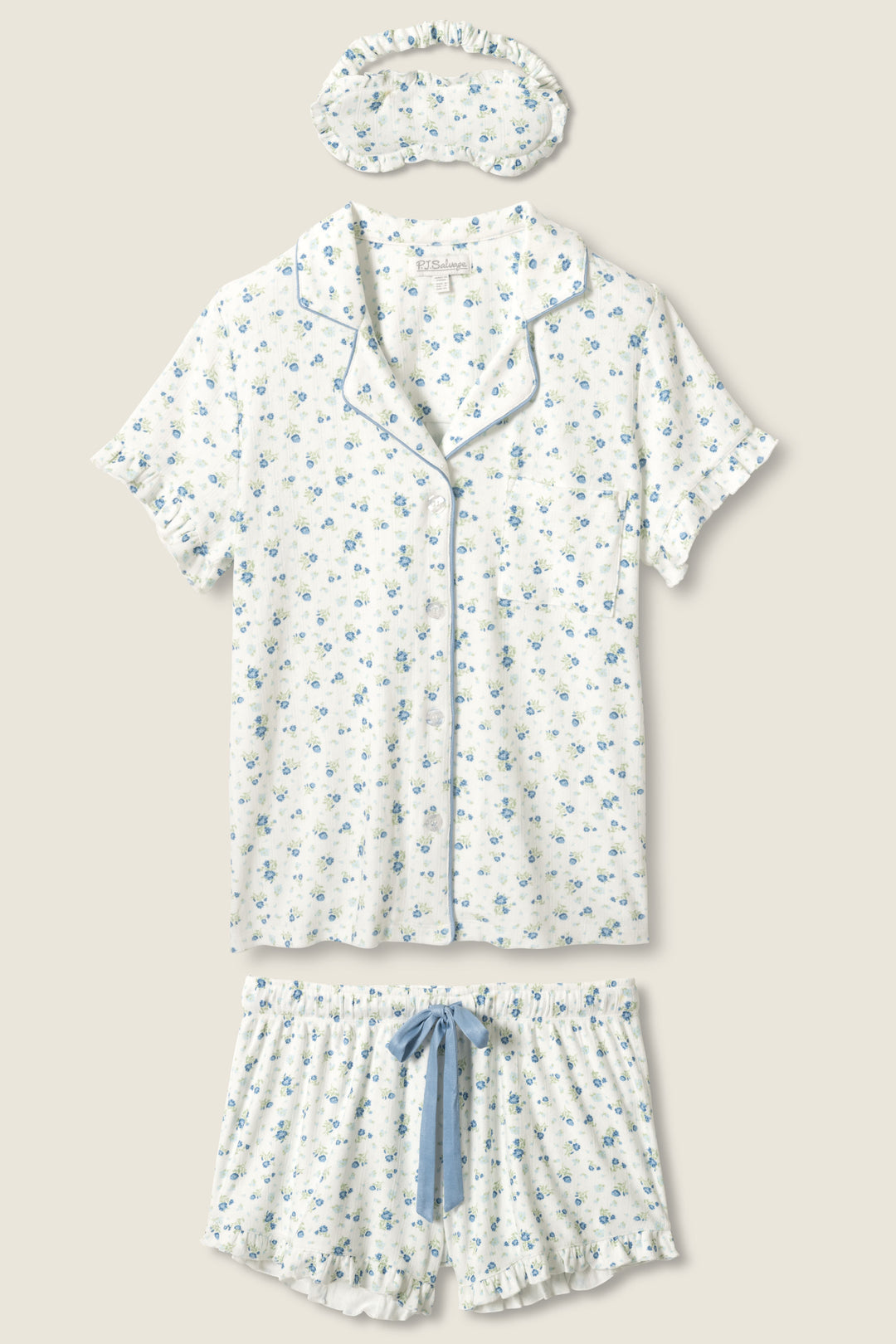 The More Amour Ditsy Floral 3-Piece Pointelle PJ Set by P.J. Salvage includes a short-sleeve button-up top, shorts with a blue drawstring, and a sleep mask, all in white fabric with blue floral print and light blue piping.
