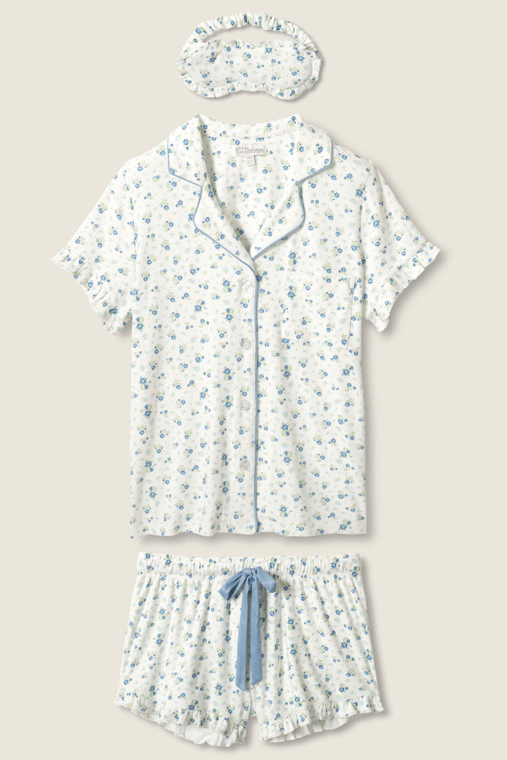 The More Amour Ditsy Floral 3-Piece Pointelle PJ Set by P.J. Salvage includes a short-sleeve button-up top, shorts with a blue drawstring, and a sleep mask, all in white fabric with blue floral print and light blue piping.