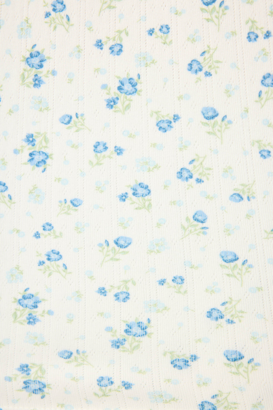 The More Amour Ditsy Floral 3-Piece Pointelle PJ Set by P.J. Salvage features white fabric with evenly spaced small blue flowers, light green leaves, and subtle vertical textured lines that enhance the background.