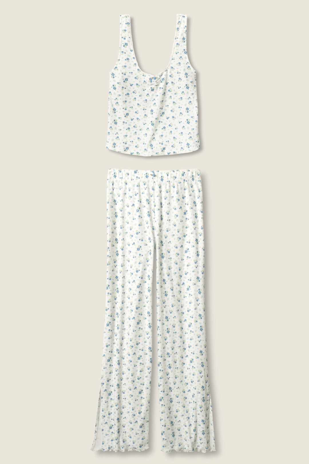 The More Amour Ditsy Floral Pointelle PJ Set by P.J. Salvage features a sleeveless white top and matching long pants with a small blue floral print, displayed flat on a light beige background.