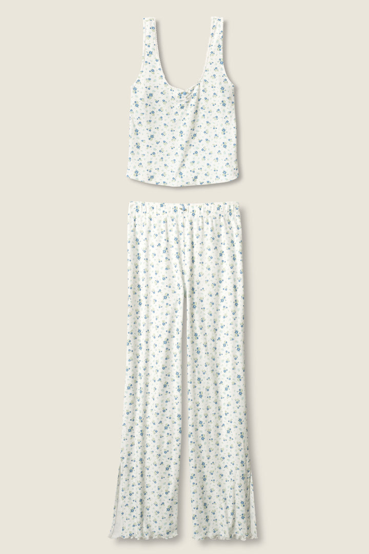 The More Amour Ditsy Floral Pointelle PJ Set by P.J. Salvage features a sleeveless white top and matching long pants with a small blue floral print, displayed flat on a light beige background.