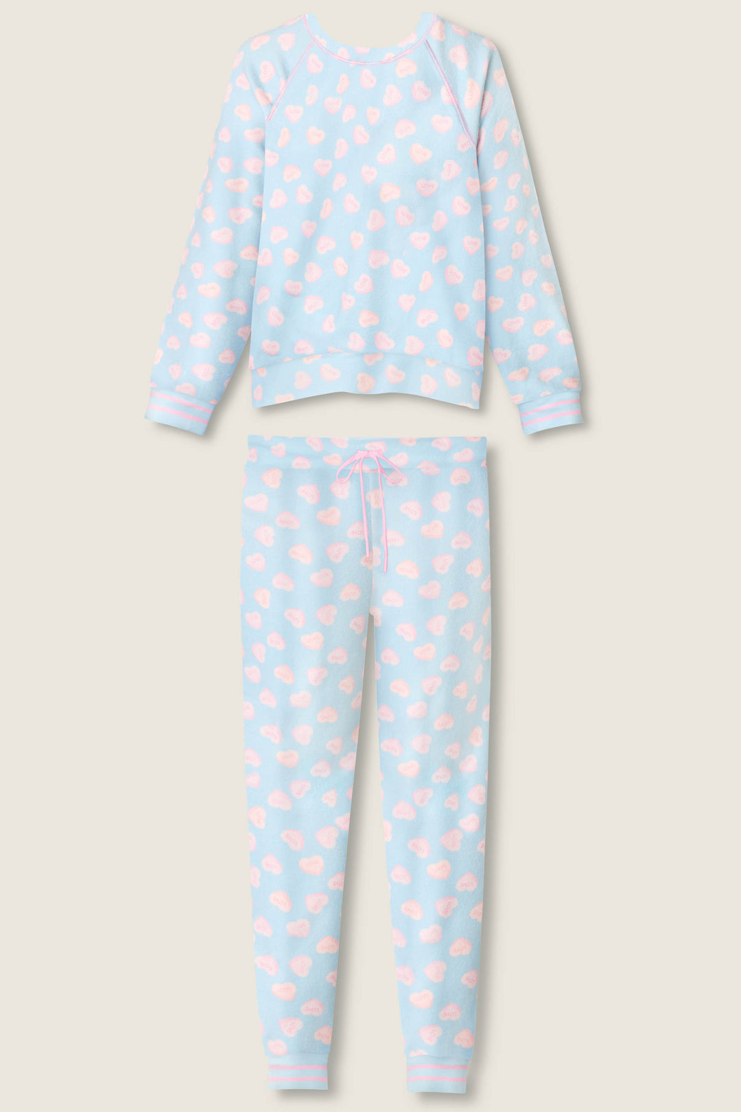 The P.J. Salvage Sweetheart Love Hearts Print Peachy PJ Set includes a long-sleeve top and pants, both in light blue with white cloud and pink heart prints, plus a pink waist drawstring on the pants.