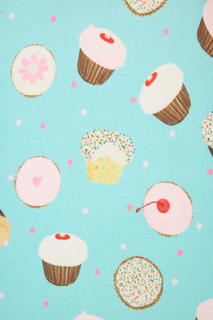 The Sweet Life Cupcake Print PJ Set by P.J. Salvage features cupcakes, cookies, and muffins with colorful decorations on a light blue background, scattered with pink and white stars.