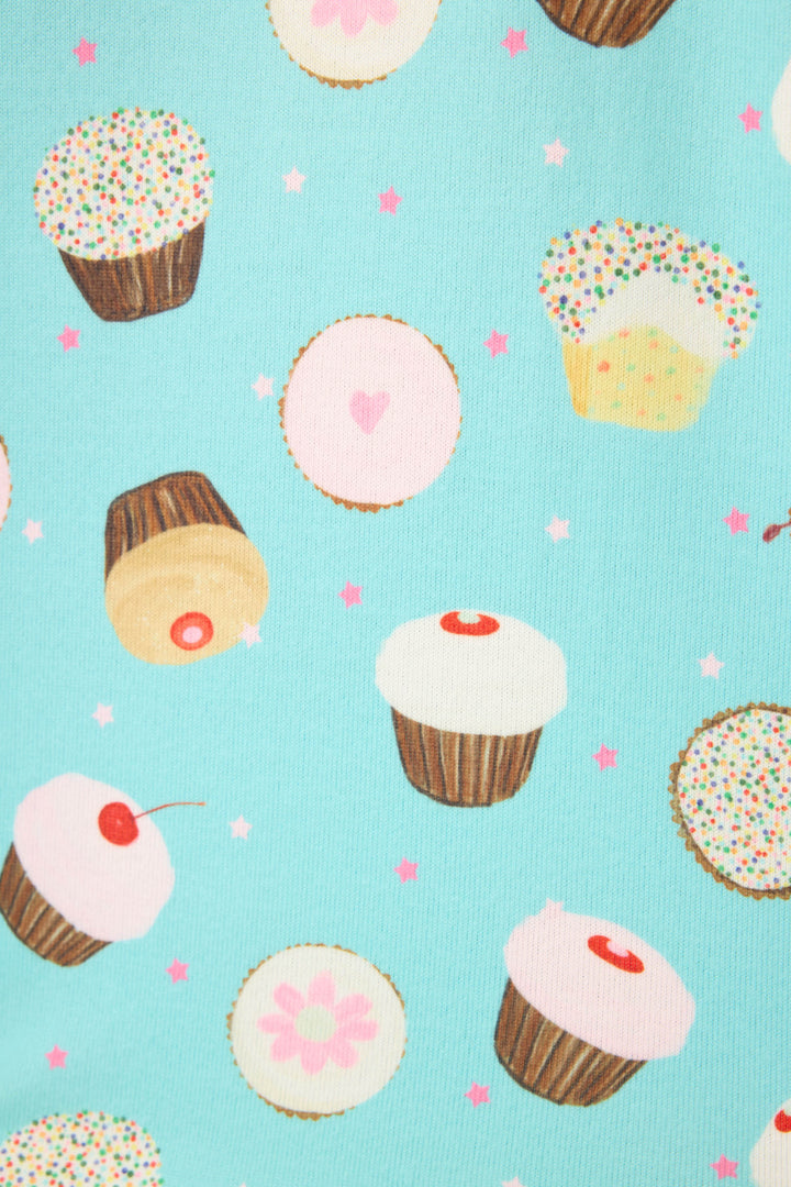 The Sweet Life Cupcake Print 3-Piece PJ Set by P.J. Salvage features cupcakes with white icing and cherries, decorated cookies, and sprinkled treats on a light blue background with pink stars.