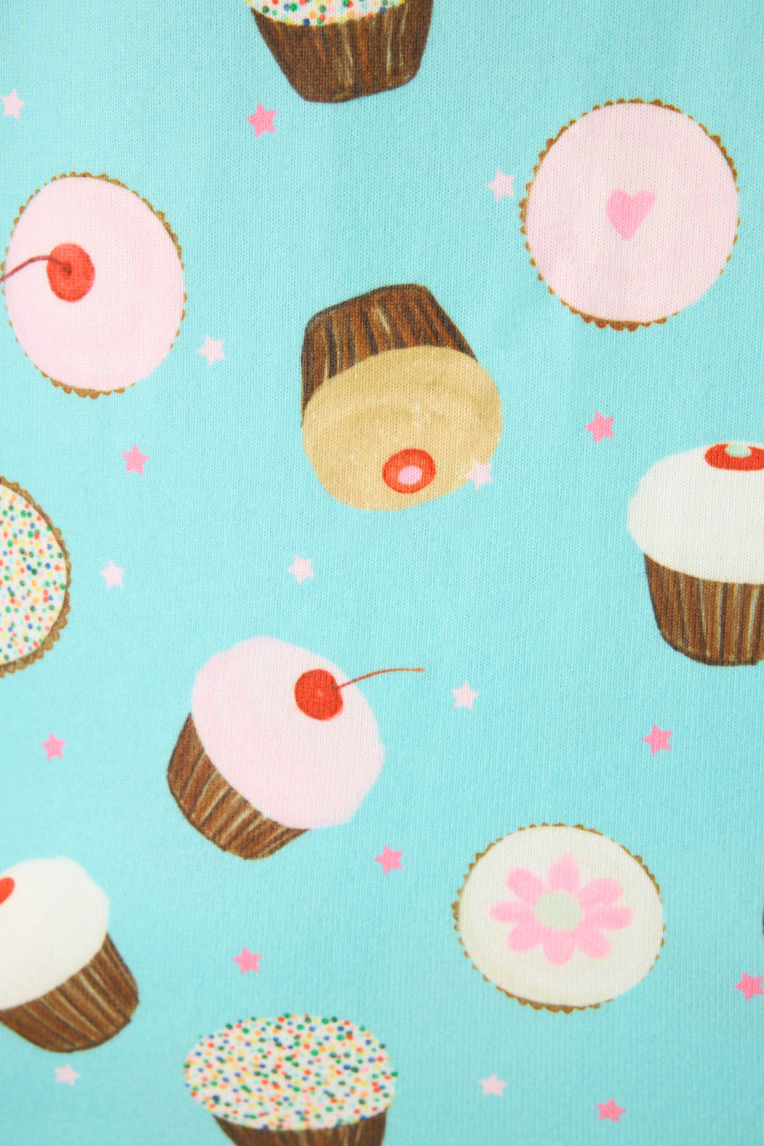 The Sweet Life Cupcake Print 3-Piece Plus Size PJ Set by P.J. Salvage features patterned fabric with assorted cupcakes—pink frosting, sprinkles, cherries—on a light blue background scattered with pink stars.