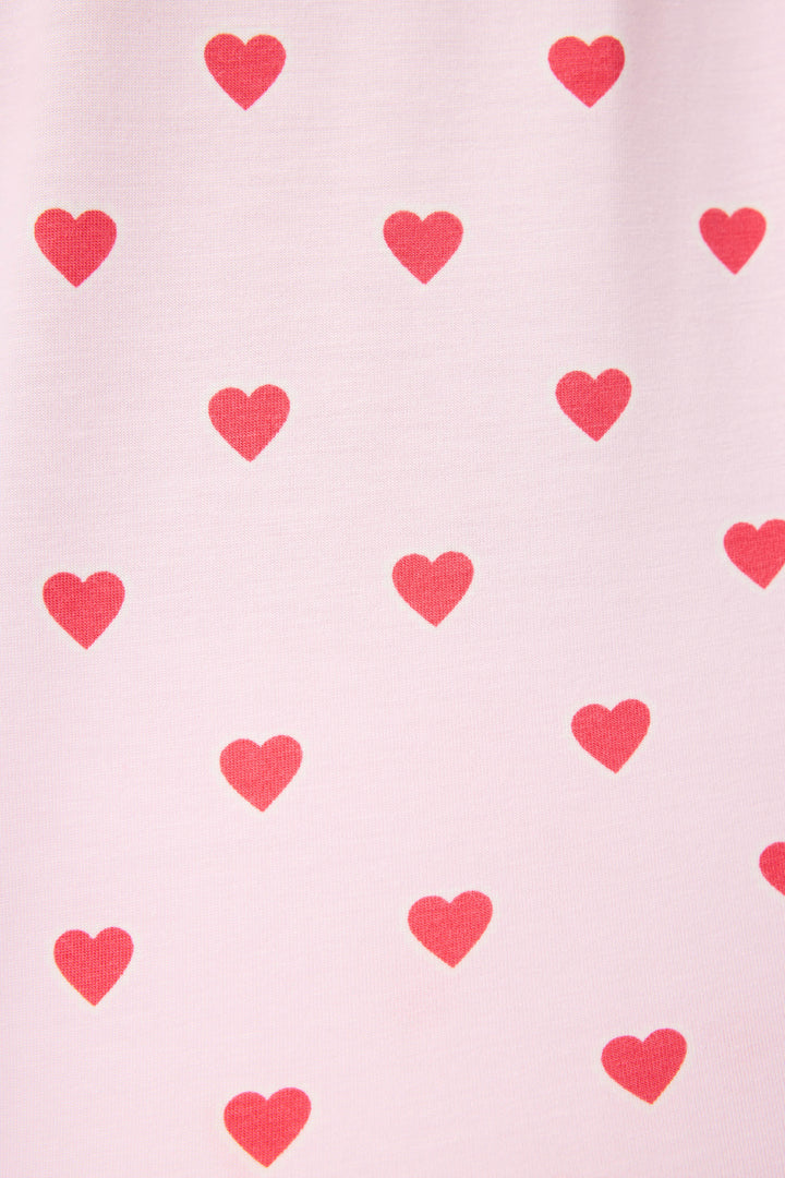 The Wildest Dreams Heart Print 3-Piece PJ Set by P.J. Salvage features a light pink fabric adorned with evenly spaced red hearts arranged in rows.