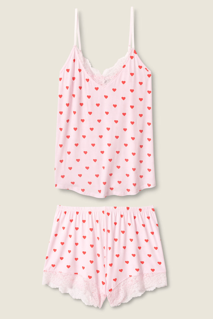 The Wildest Dreams Heart Print Shorts Set by P.J. Salvage features a pink camisole top and shorts with small red hearts and white lace trim, shown laid flat on a neutral background.