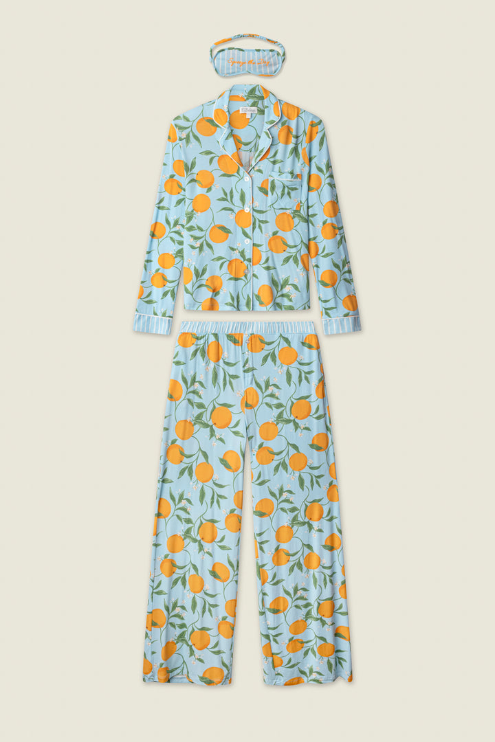 The Citrus Dreams Morning Squeeze Long 3-Piece PJ Set by P.J. Salvage features a blue women's pajama set with a button-up long sleeve top, long pants, and sleep mask—all featuring playful orange fruit and green leaf prints.