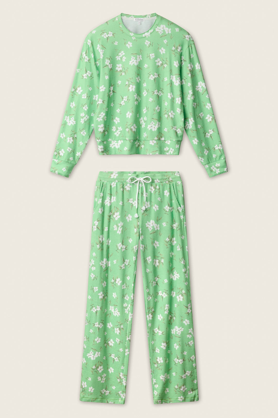 The P.J. Salvage C'est La Vie Floral Print Lounge Set features a light green long-sleeve top and pants with a white floral pattern and drawstring waistband, displayed on a neutral background.