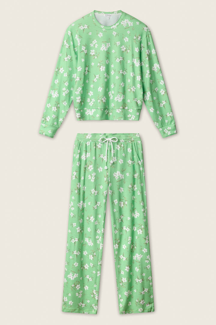 The P.J. Salvage C'est La Vie Floral Print Lounge Set features a light green long-sleeve top and pants with a white floral pattern and drawstring waistband, displayed on a neutral background.