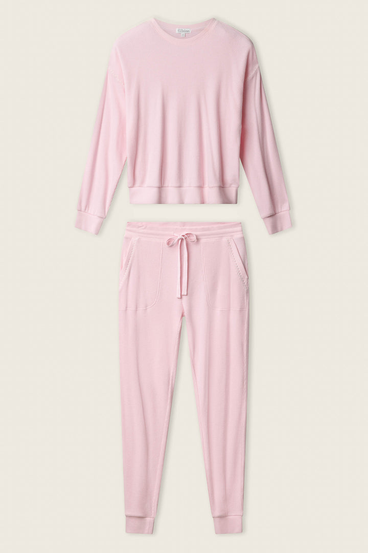 The P.J. Salvage Cross Stitch Casuals Ballet Pink Lounge Set features a long-sleeve crewneck top and matching jogger pants with cuffs and front pockets, shown laid flat on a neutral background.