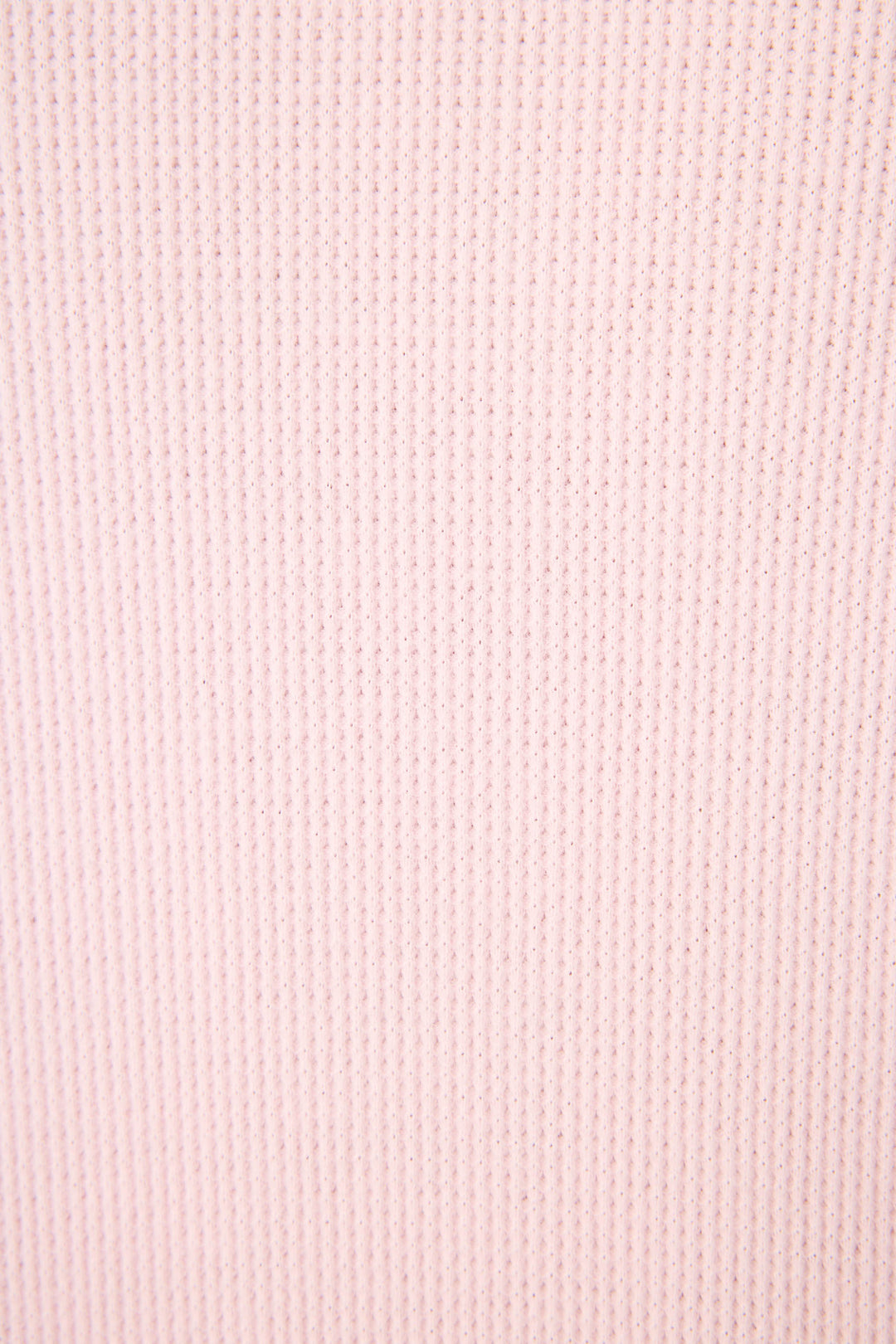 A close-up of the Cross Stitch Casuals Ballet Pink Lounge Set by P.J. Salvage shows its light pink fabric with a vertical ribbed texture and fine, evenly spaced lines.