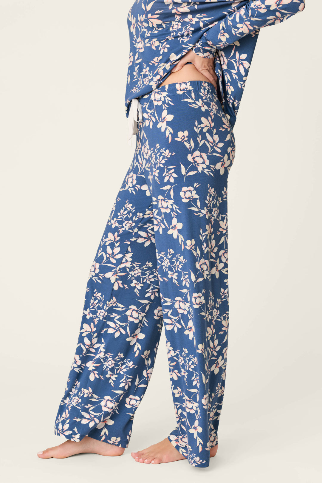 A person stands barefoot on a light background, wearing P.J. Salvage Flora Dreams Twilight Garden Open Leg PJ Pants. Only the lower half of their body is visible.
